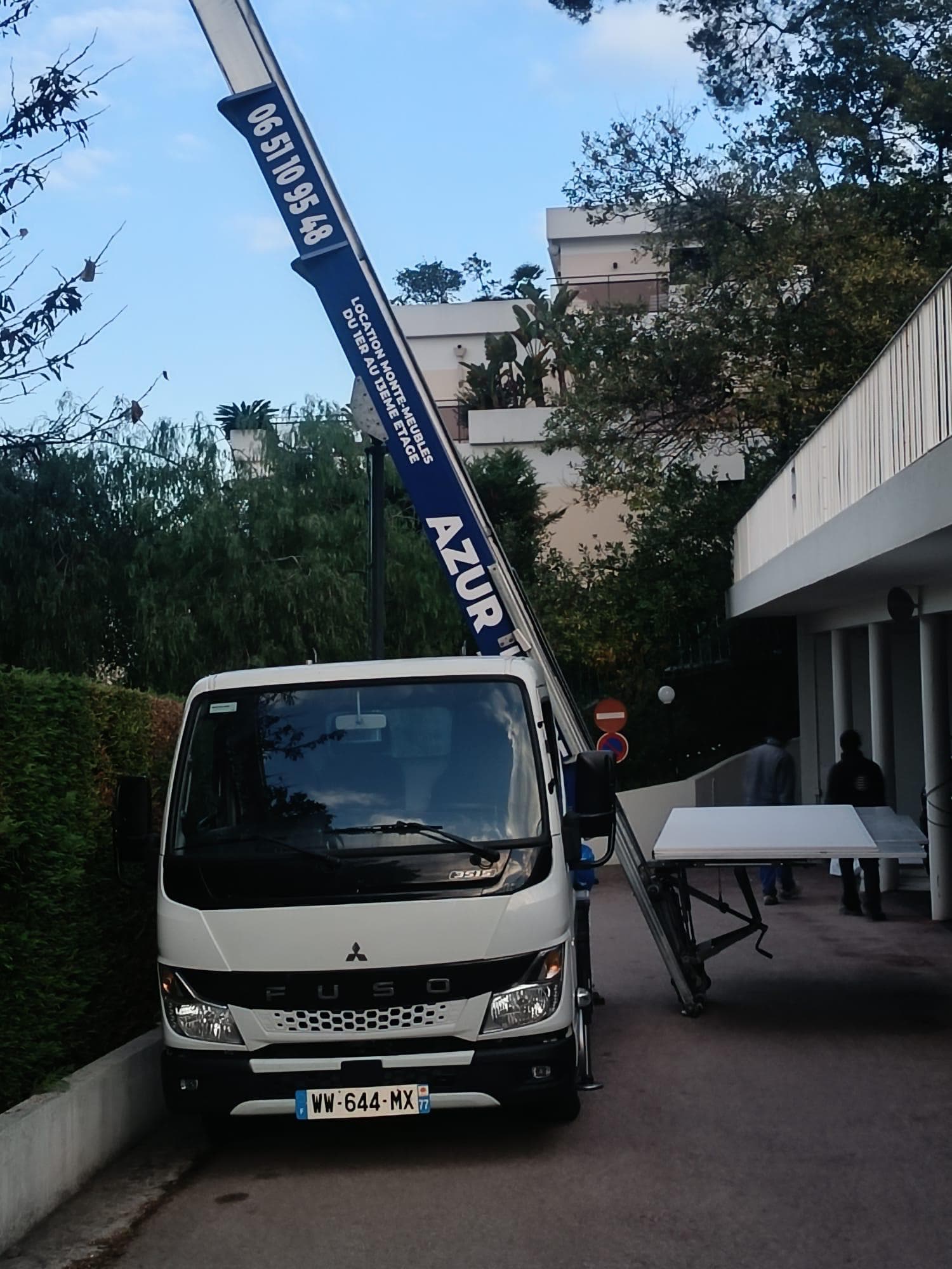 Camion monte-meuble Fuso deploye devant un immeuble pour un demenagement en etage a Cannes