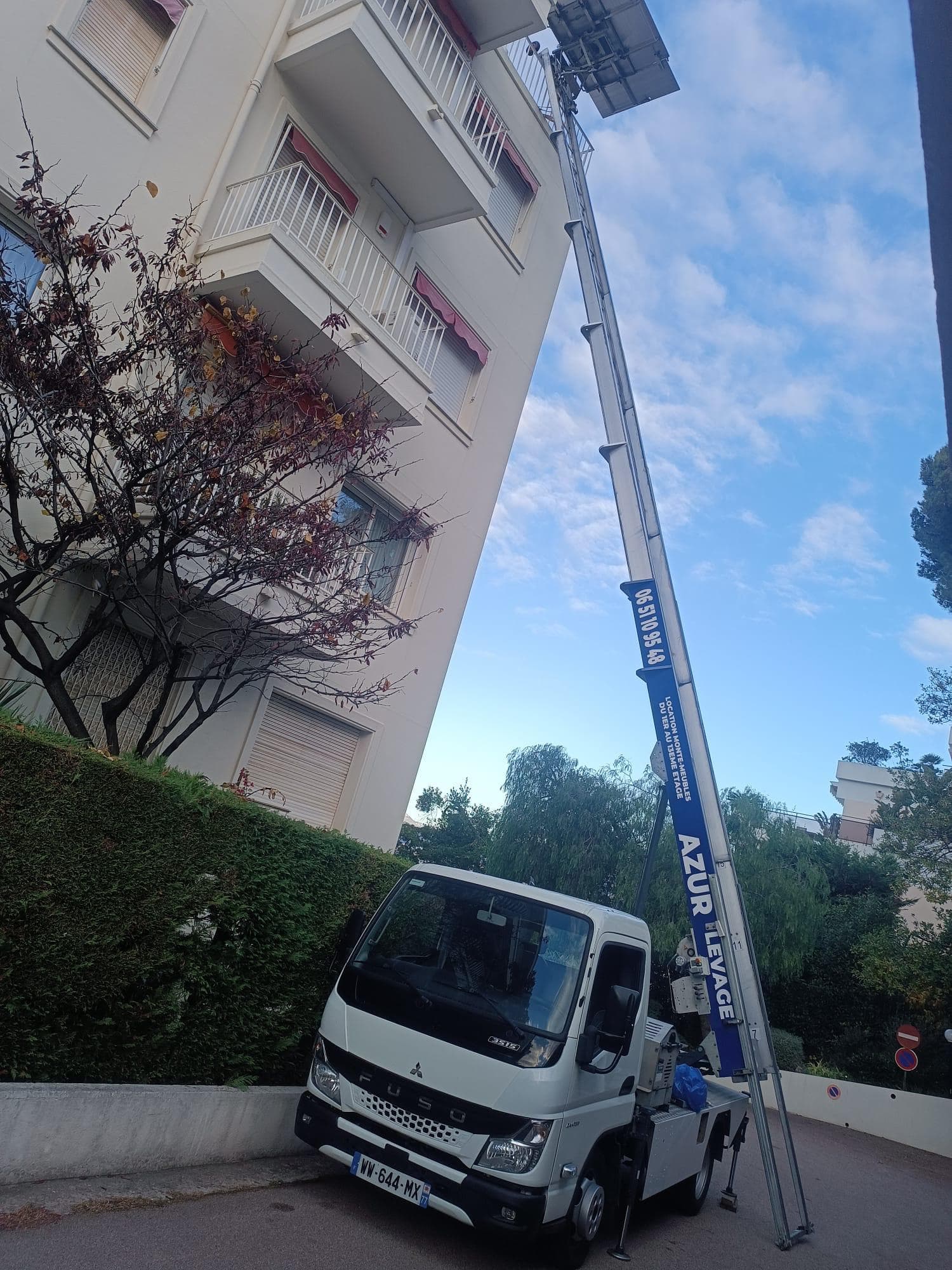 Monte-meuble deploye le long d'un immeuble haussmannien parisien pour un demenagement par les etages