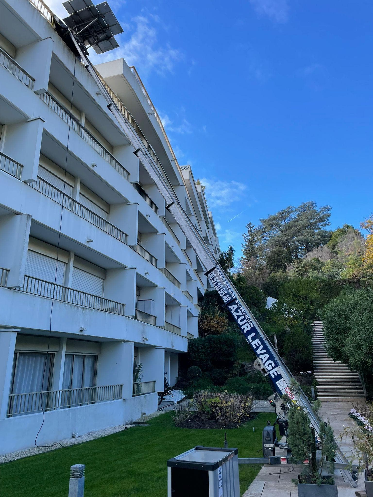 Monte-meuble deploye le long d'une residence de plusieurs etages mesurant la hauteur de levage necessaire